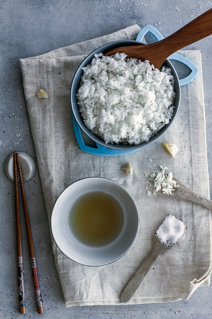 White rice in bowl, sauce in bowl served on table with chopsticks