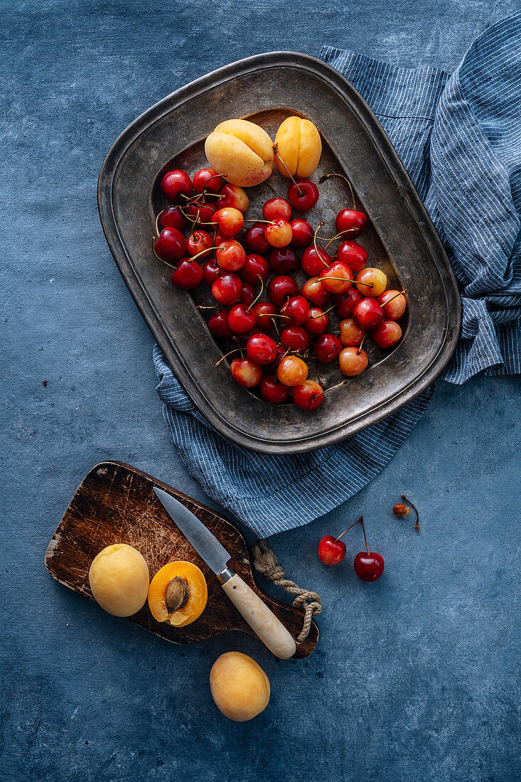 Cherry and apricots served on plate on a rustic background