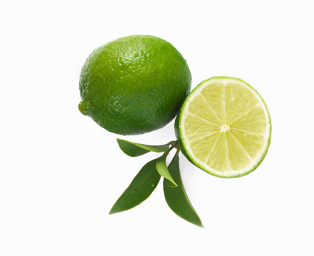 Whole lime and half a lime against a white background