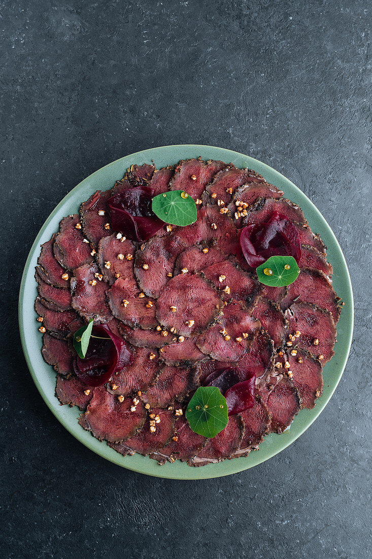 Meat carpaccio served with boiled beetroot on plate