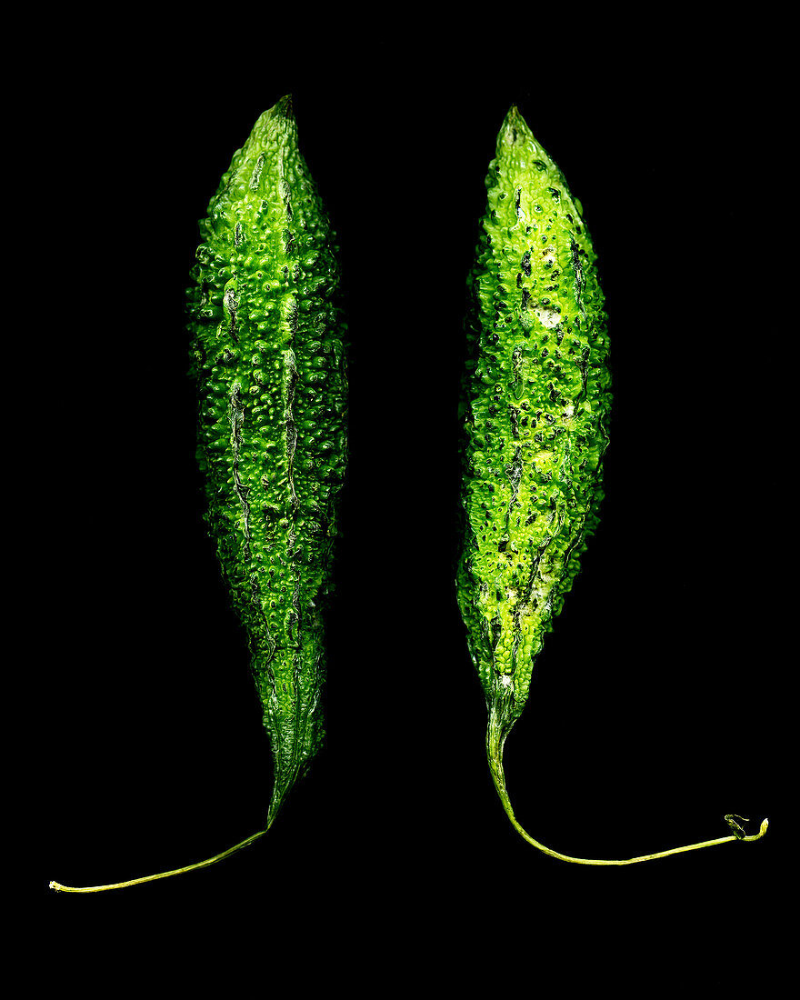 Two butter gourds against a black background