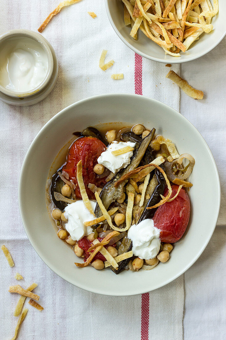 Baked aubergine, tomatoes with chickpeas, served with strips of pita bread and yogurt