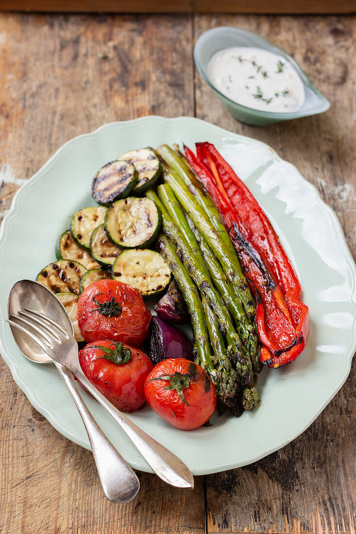 Gegrilltes Gemüse (Tomaten, rote Zwiebeln, Zucchini, Spargel, roter Paprika) mit Joghurtsauce
