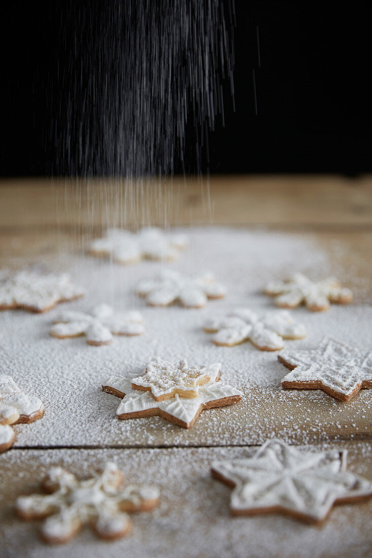 Dusting snowflake cookies with powdered sugar