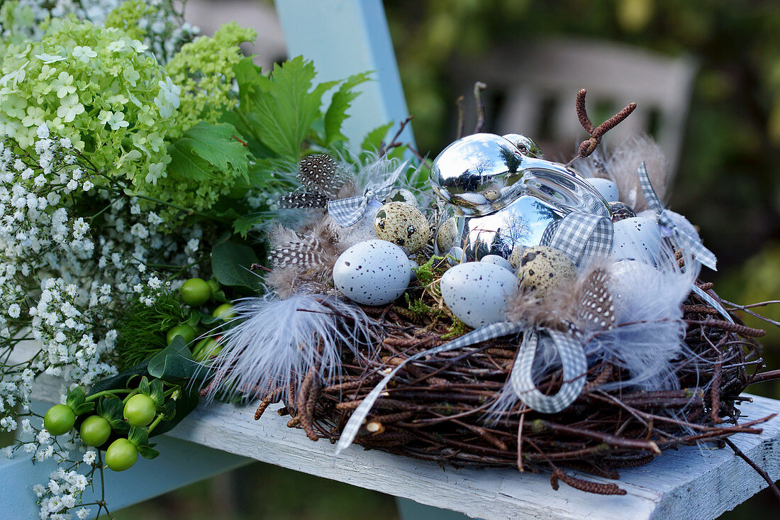 Easter nest of birch twigs with feathers, Easter eggs and Easter bunny