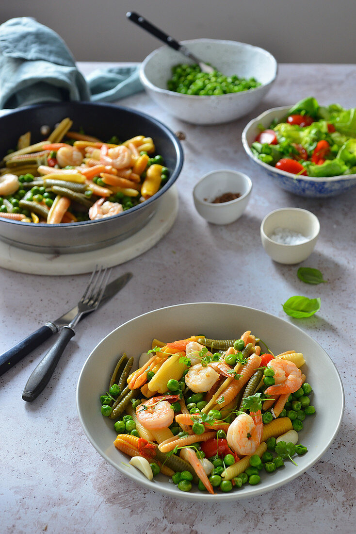 Colorful pasta with shrimps and green peas in a white wine sauce