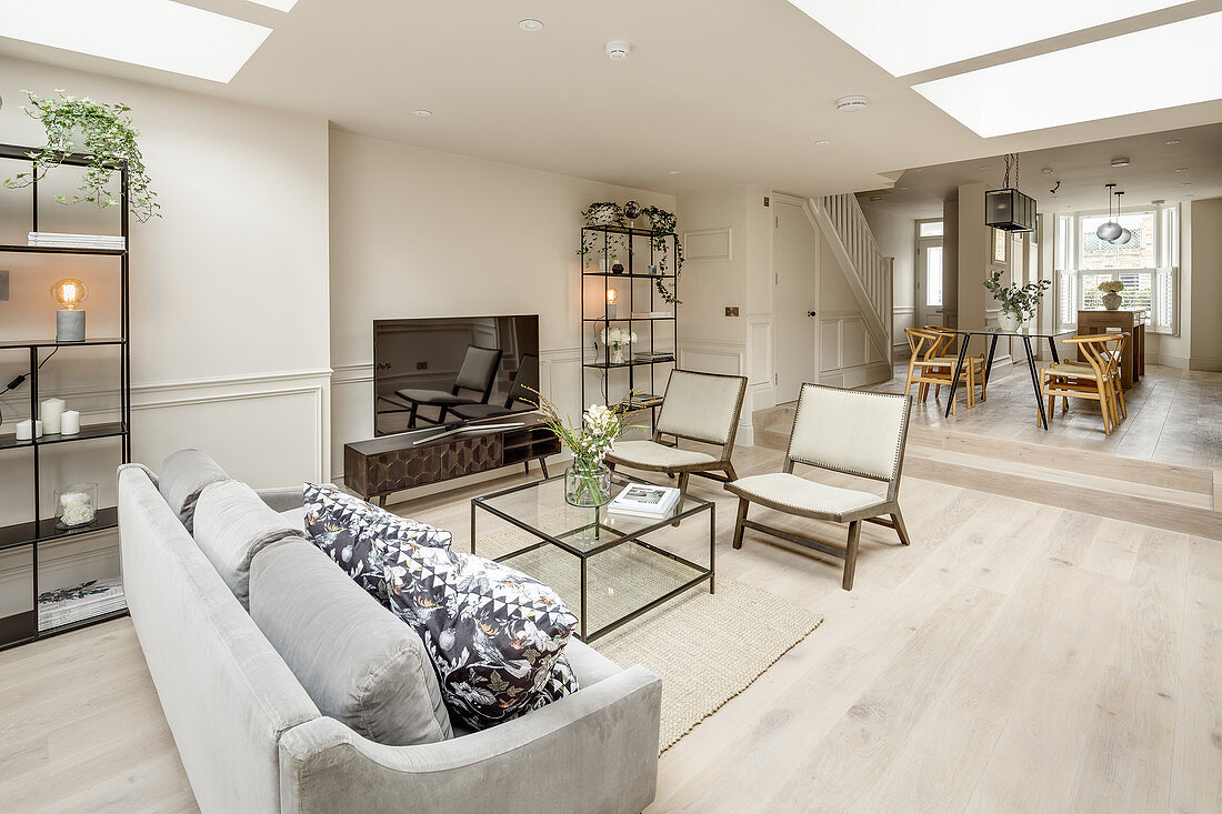 Seating area around TV and dining table on raised level in open-plan living room