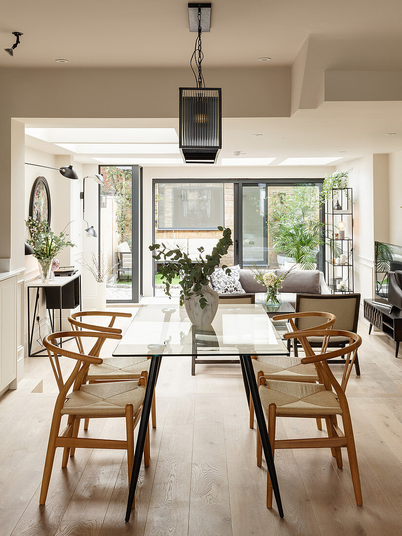 Glass dining table in raised dining area of open-plan interior