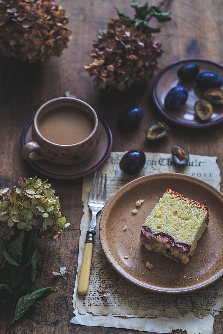 Slice of a plum yeast cake and a cup of coffee