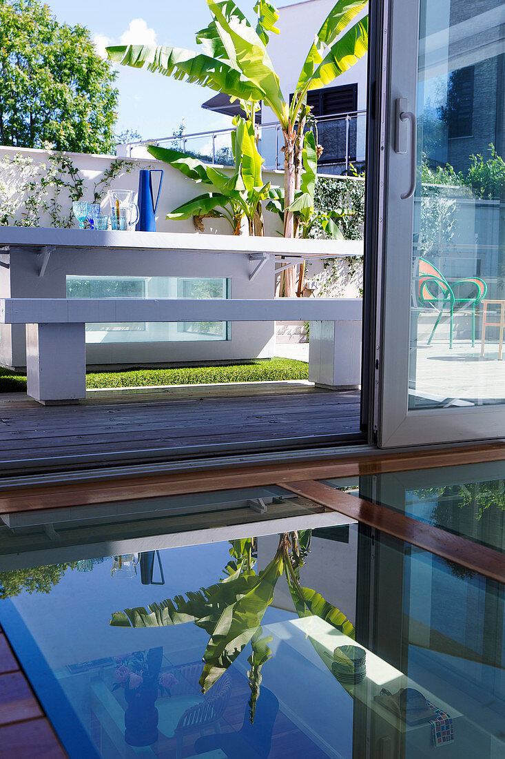 Glasboden vor geöffneter Tür, Blick auf Terrasse mit Tisch