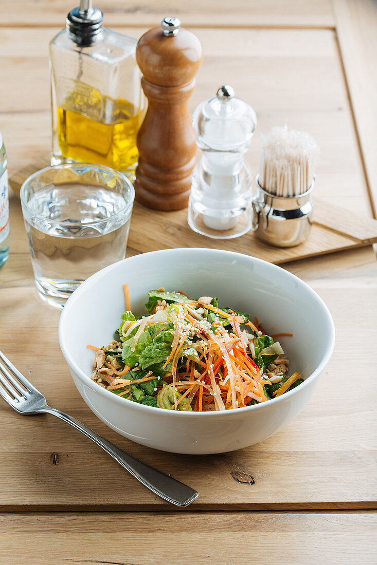 Tasty salad with soybean sprout and seeds in a bowl on wooden table