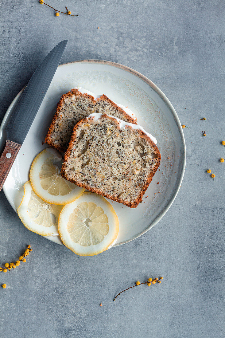 Pieces of lemon and poppy seeds cake served on white plates