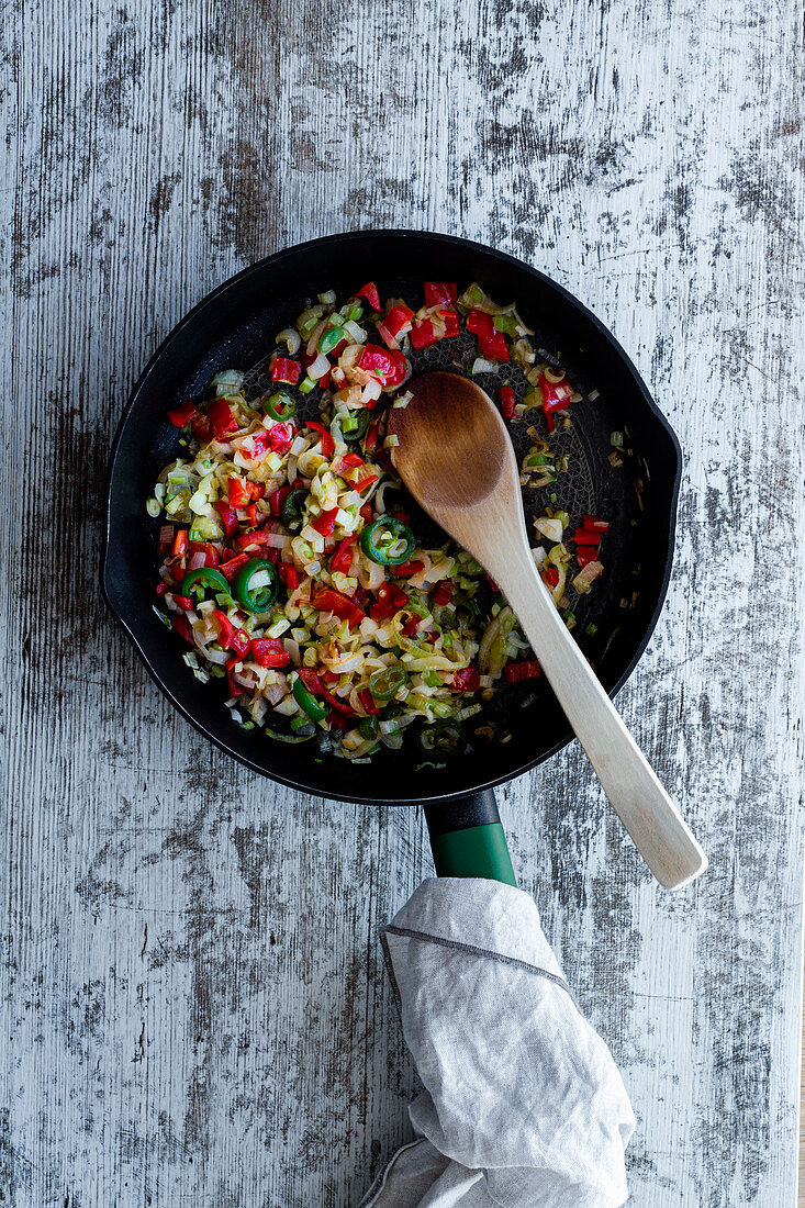 Garlic with pepper and onion fried gently in pan on kitchen