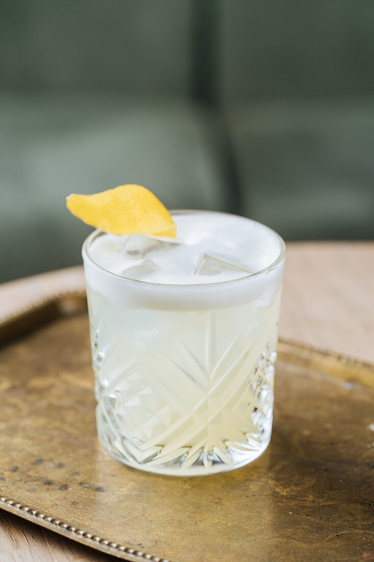 Cocktail mit Schaum, Gin und Zitrone im Kristallglas