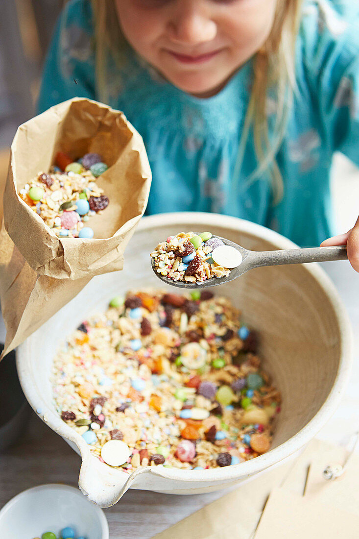 Girl mixing cereals and sweets