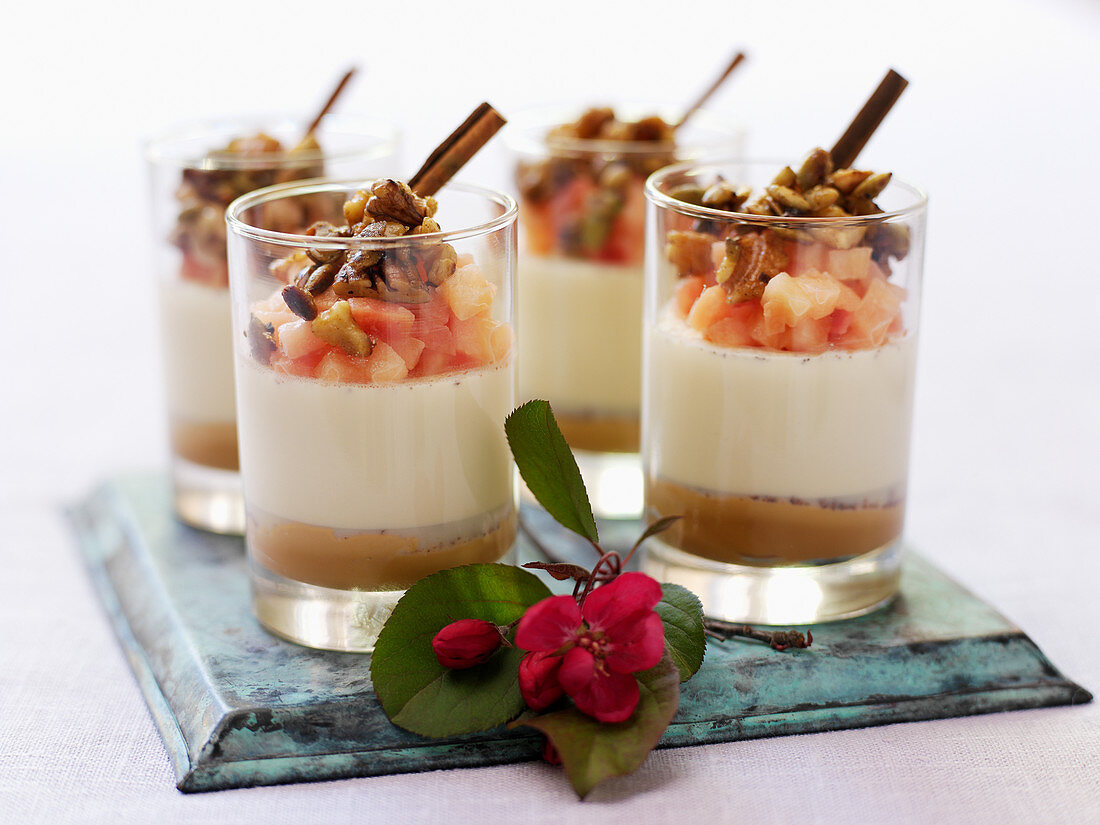 Layered panna cotta desserts with cinnamon cream, fruits and nuts