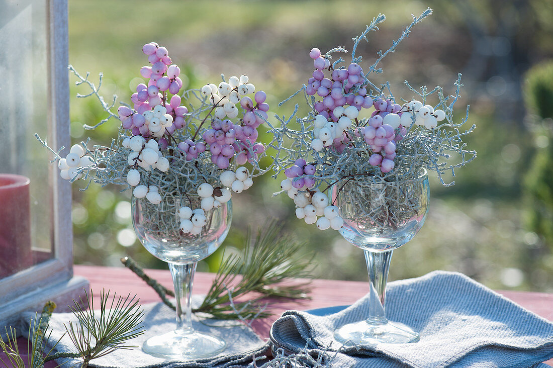 Autumn decoration idea with snowberries and ragwort in wine glasses