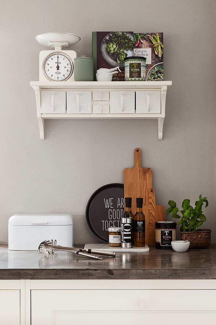 Various kitchen utensils on a kitchen worktop and a vintage drawer shelf