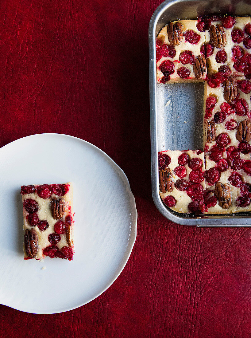 Cranberrykuchen mit Pekannüssen im Backblech und auf Teller