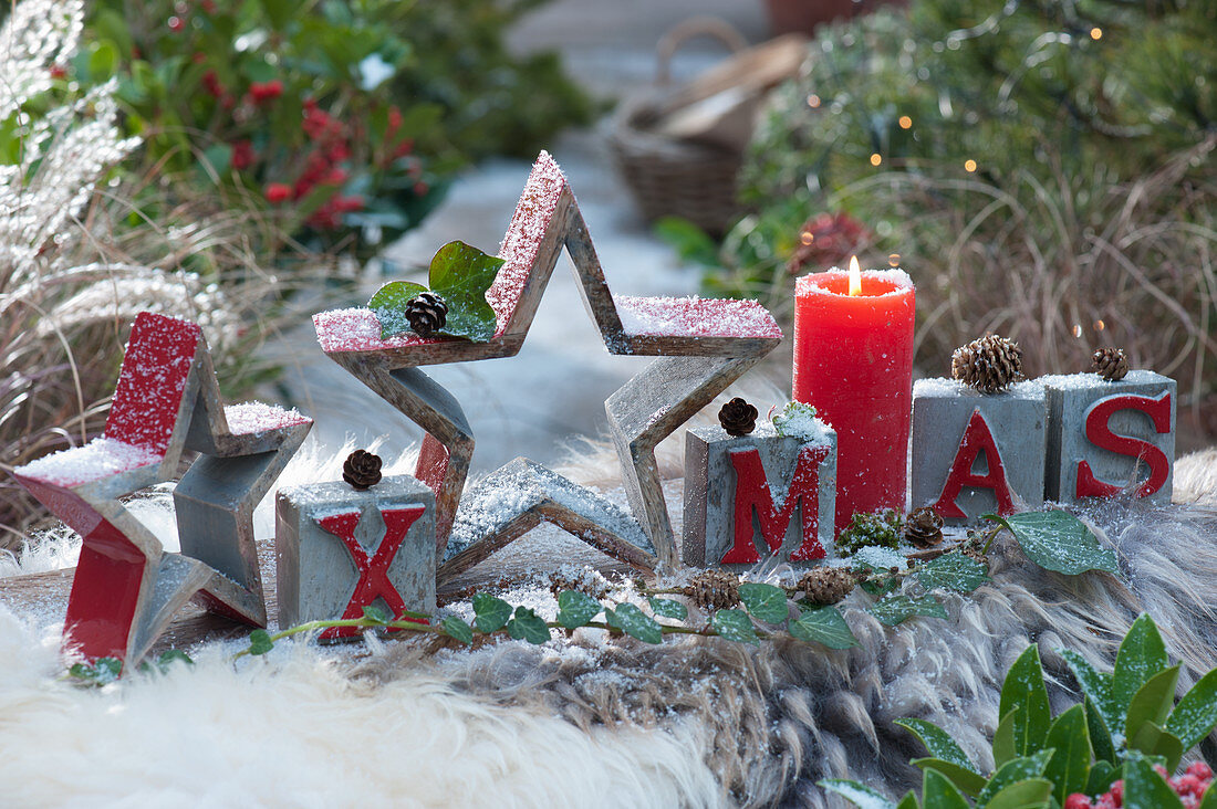 Modern Christmas decoration with stars, candle and XMAS message