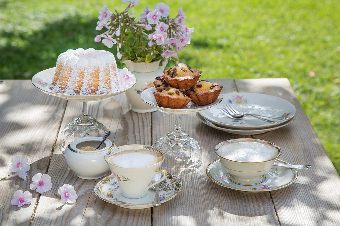Table set for afternoon coffee with vintage-style crockery and DIY cake stands