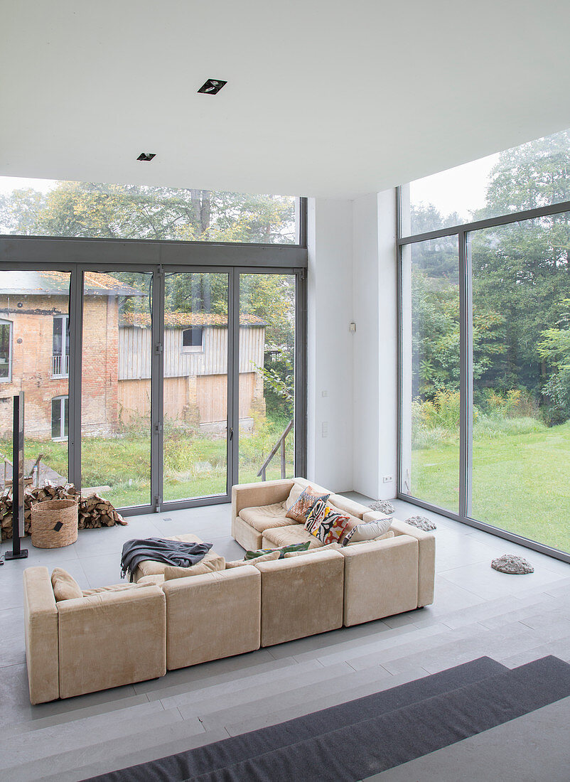 Beige sofa in modern living room with glass walls