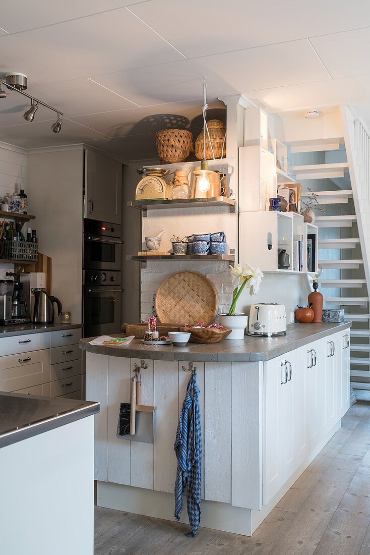 Island counter used as partition in white, open-plan, country-house kitchen