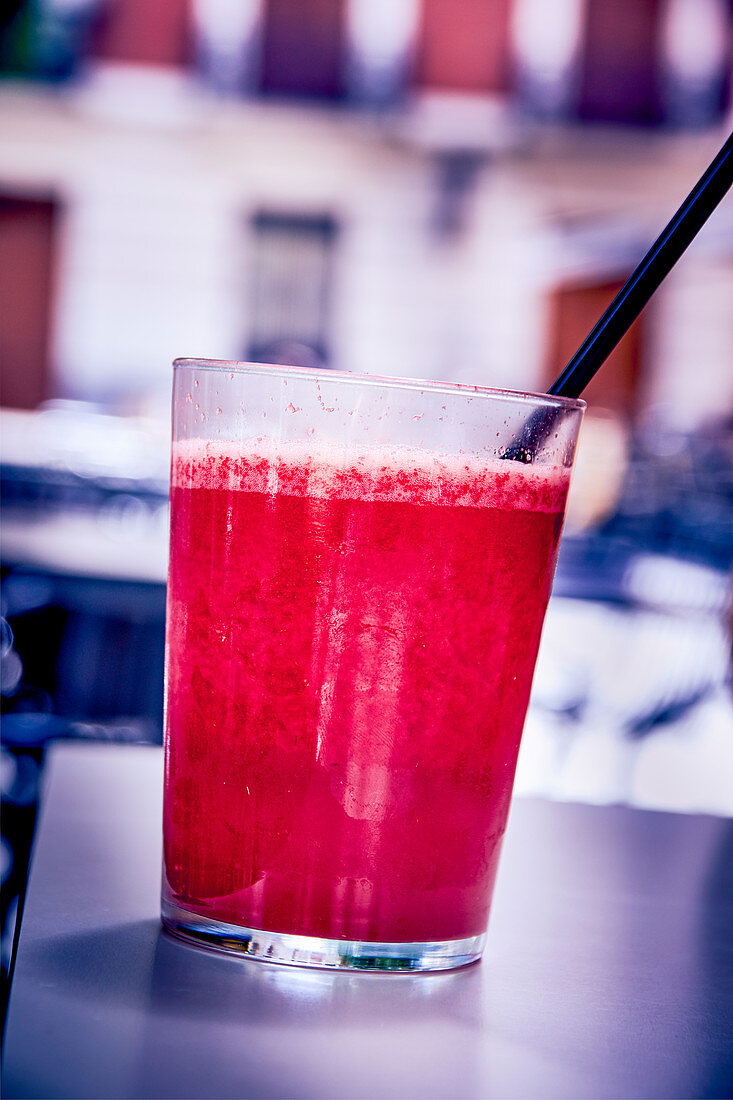 A red smoothie outside on a restaurant table