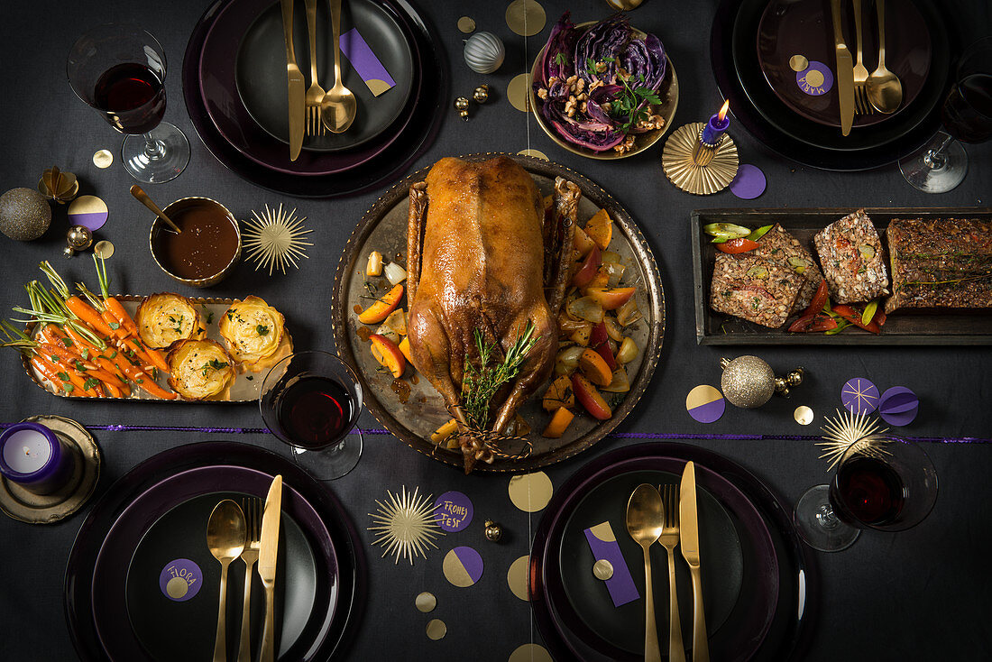 Festtagstafel zu Weihnachten mit Gans, vegetarischem Nussbraten, Kartoffelgratin, Möhren und Rotkohl