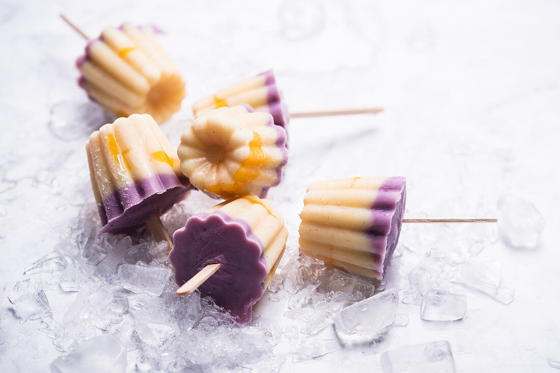 Frozen soya yoghurt on sticks with blueberries, vanilla and mango