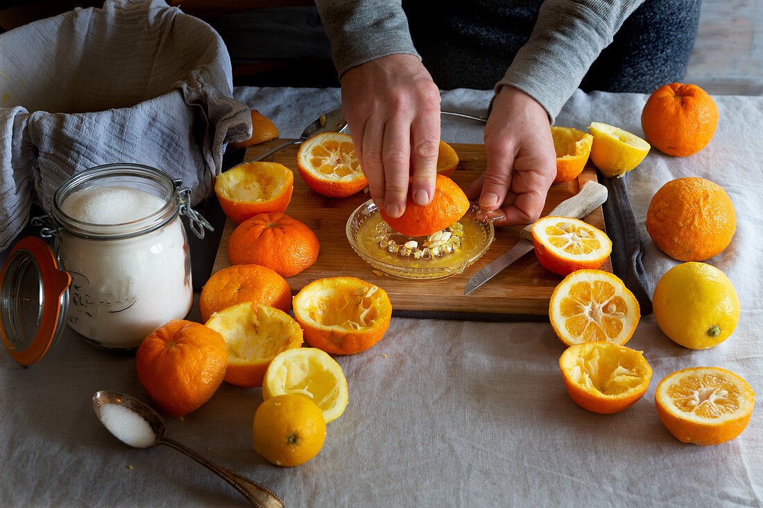Preparing orange jam from Seville oranges: squeezing out the juice