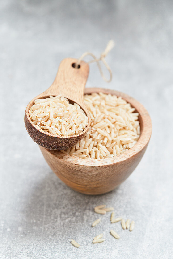 Reis im Holzschälchen und auf Holzlöffel