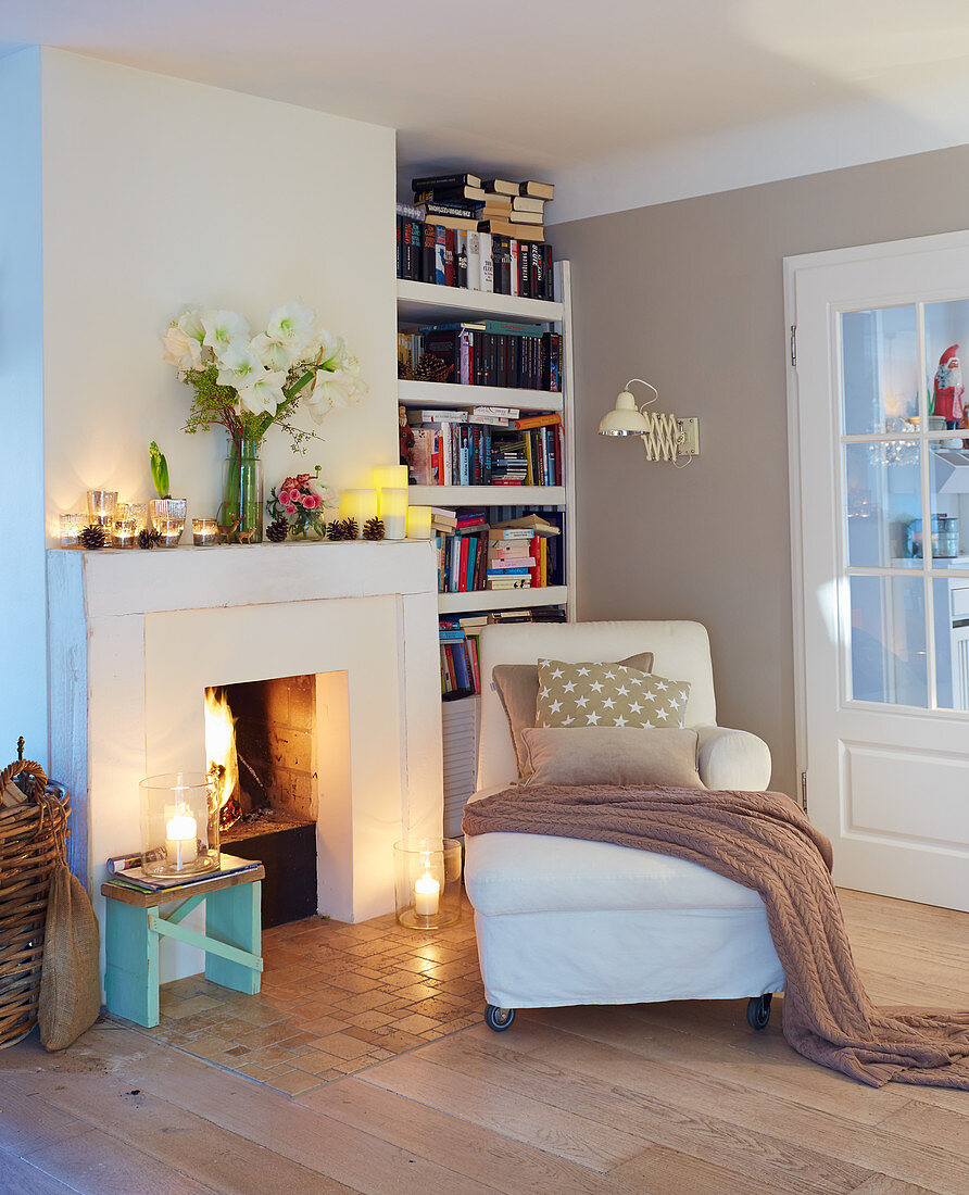 Récamier in front of open fireplace and arrangement of candles in living room