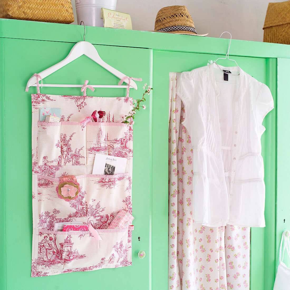 Hand-sewn organiser made from toile-de-jouy fabric hanging on wardrobe