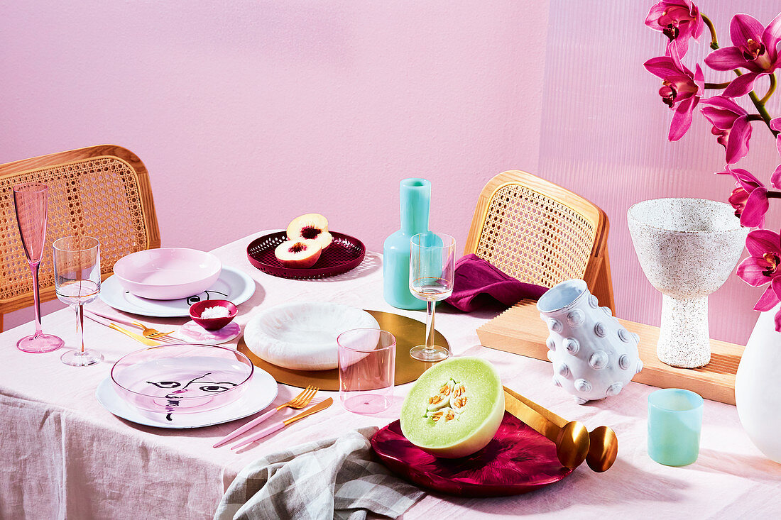 Gedeckter Tisch in Rosa mit Melone und Pfirsich