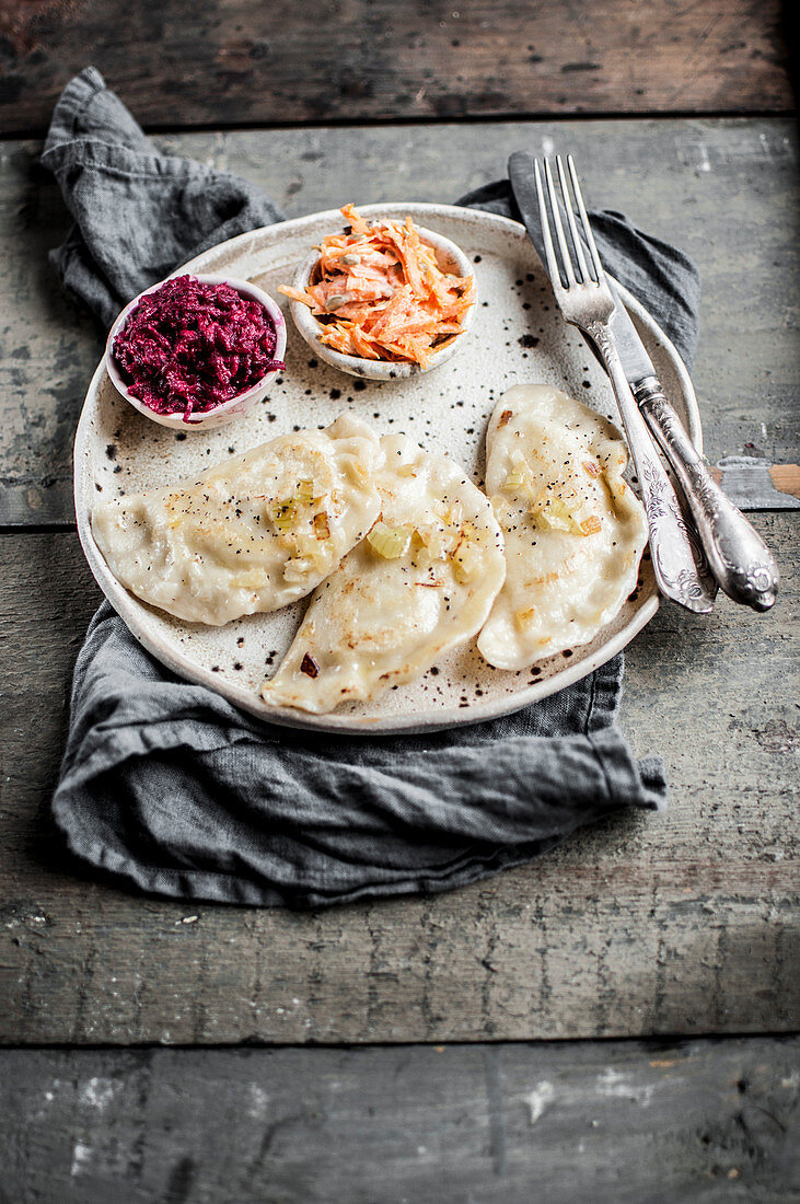 Pierogies with potatoes and cottage cheese served with beetroot salad and carrot salad