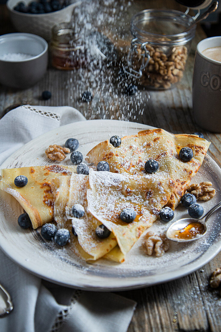 Crepes mit Blaubeeren, Walnüssen, Honig und Puderzucker fürs Frühstück