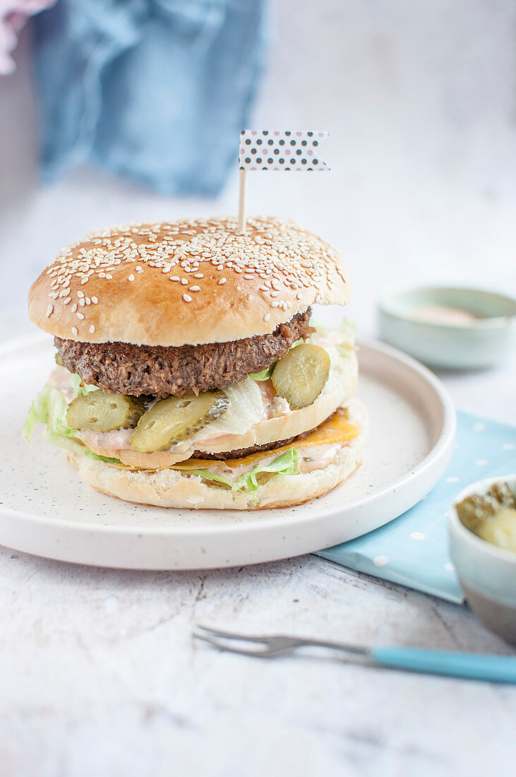 Veganer Burger mit Eisbergsalat, Essiggurken und Käseersatz