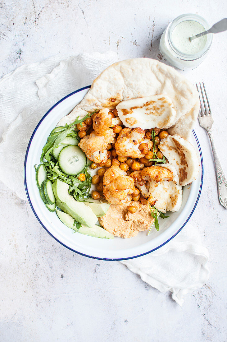 Vegetarian shawarma made with chickpeas and cauliflower, served with naan bread and fried halloumi cheese
