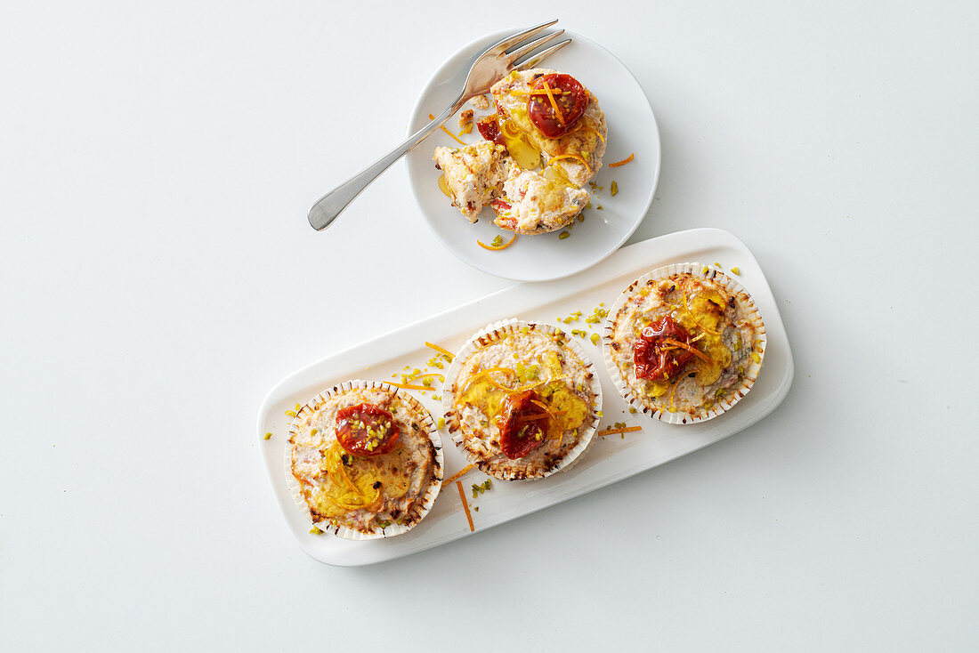 Cream cheese tartlets with dried tomatoes, pistachios, orange zest and honey