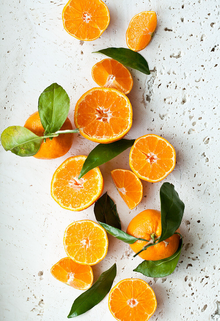 Oranges with leaves, whole, halved and slices