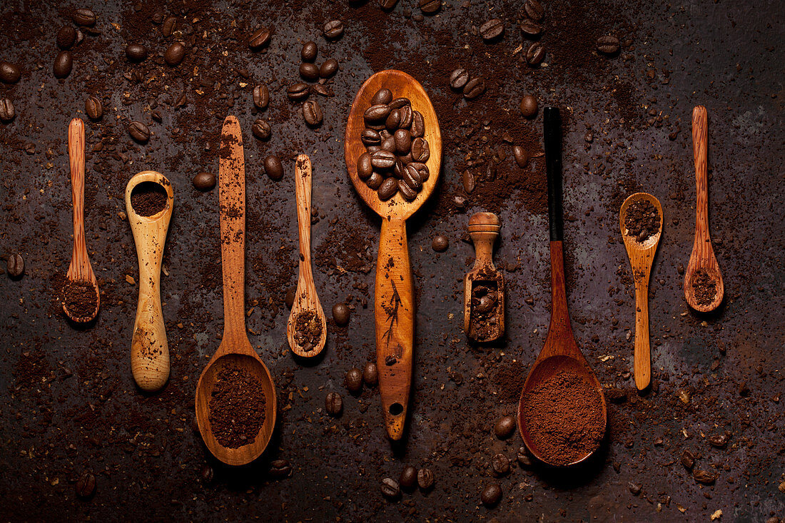 Coffee beans and Ground Coffee on Wooden Spoons in a row