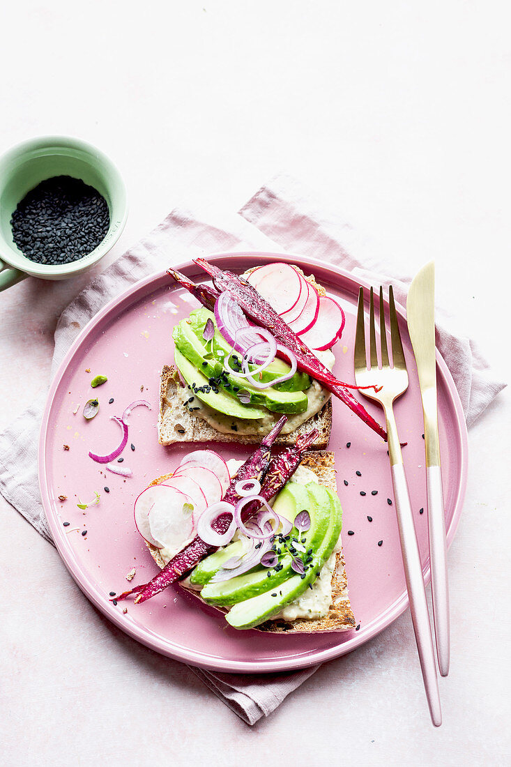 Hummus sandwich with avocado, radish, carrots, onion, blac sesam