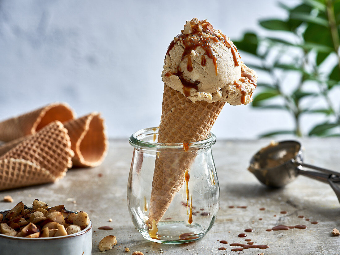 Macadamia nut ice and salted caramel sauce in a cone