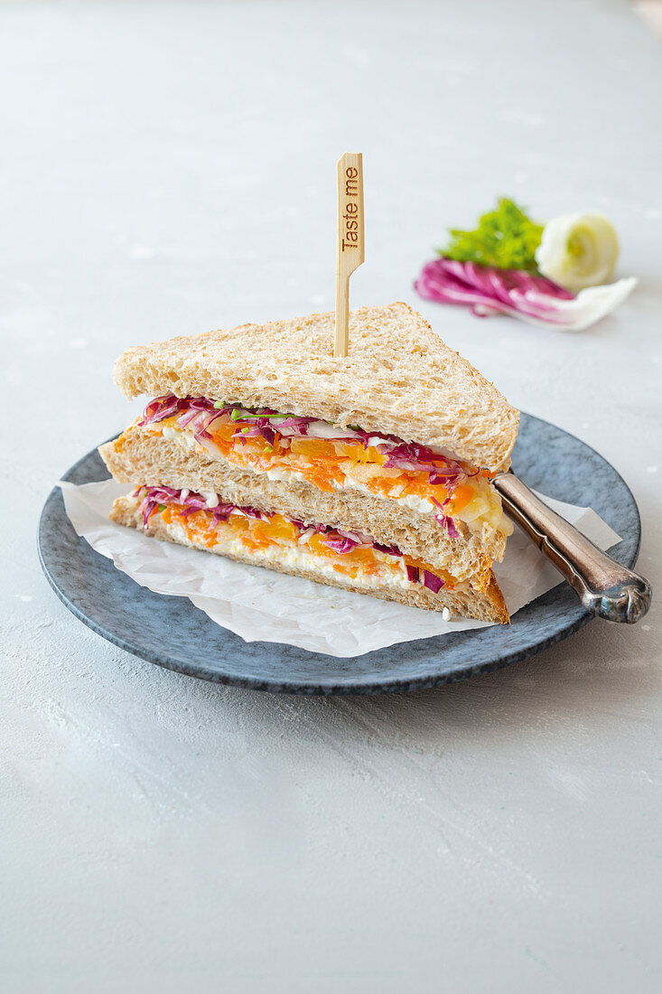 A wholemeal sandwich with cream cheese, radicchio, carrots and celmentines