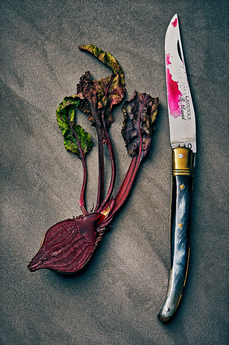 A halved beetroot with a knife