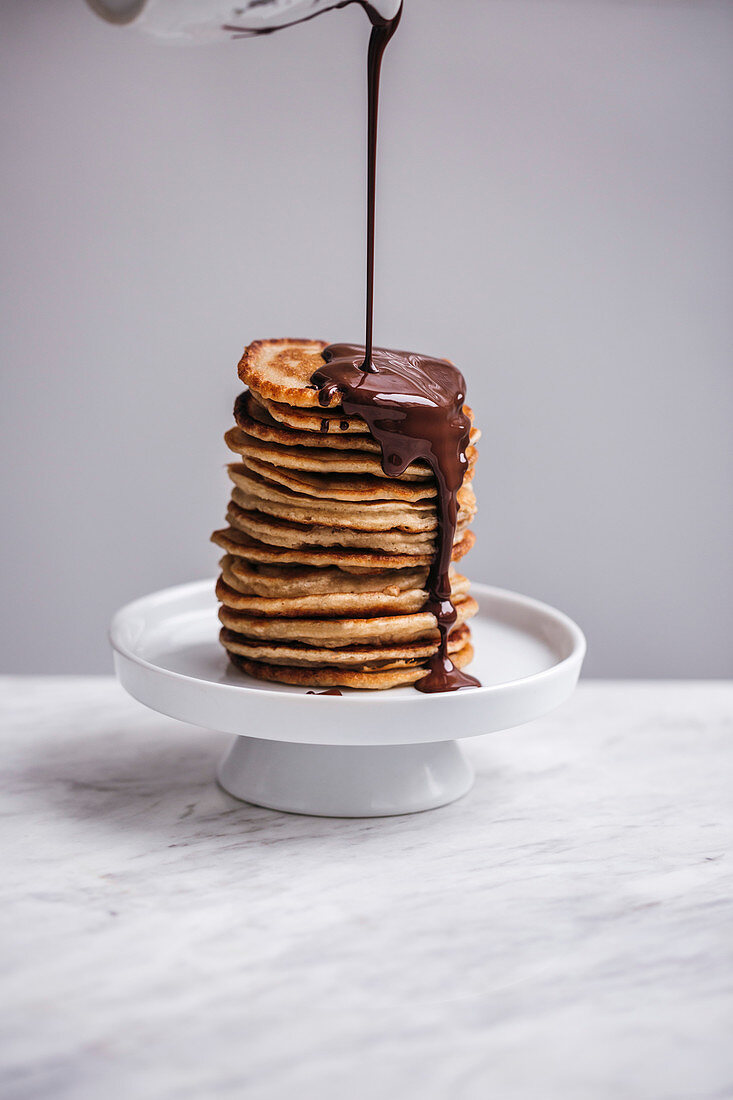 Stack of pancakes drizzled with melted chocolate
