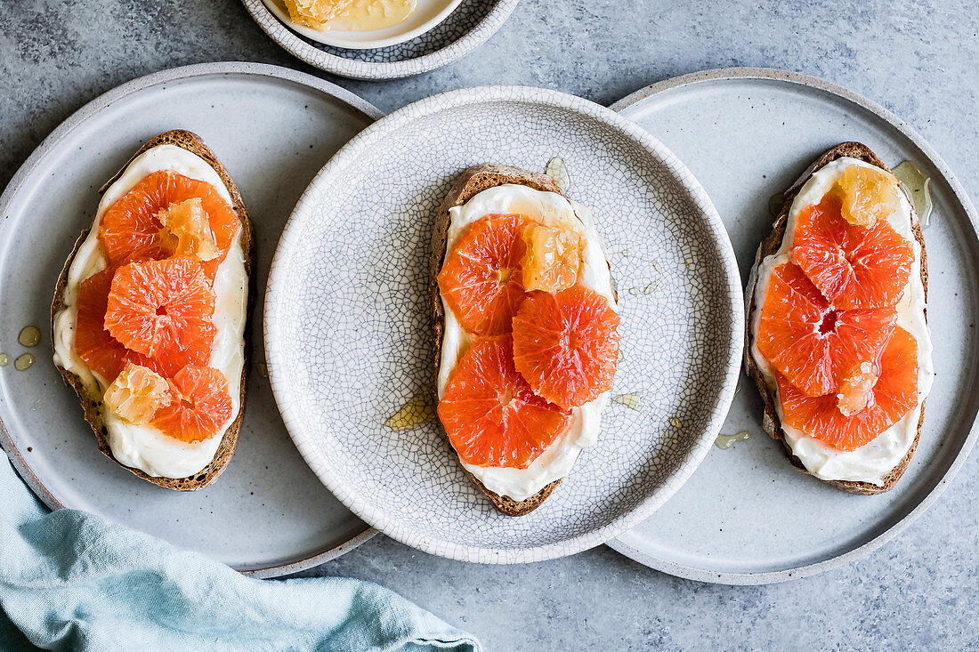 Brotscheiben mit Ricotta, Orangenscheiben und Honig