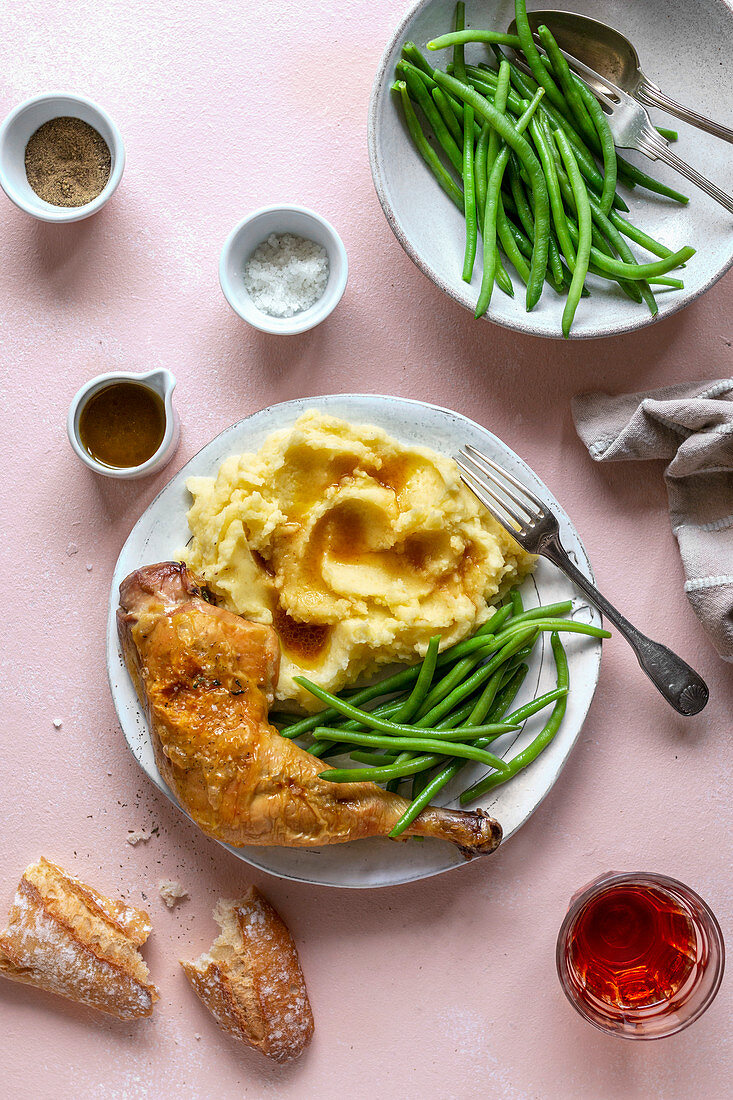Roasted chicken with mashed potatoes and green beans on a plate