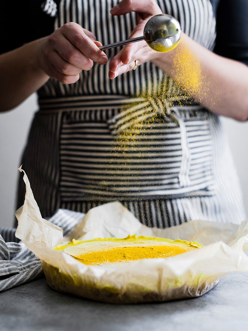 Vegan golden milk cheesecake being prepared by a chef in a kitchen